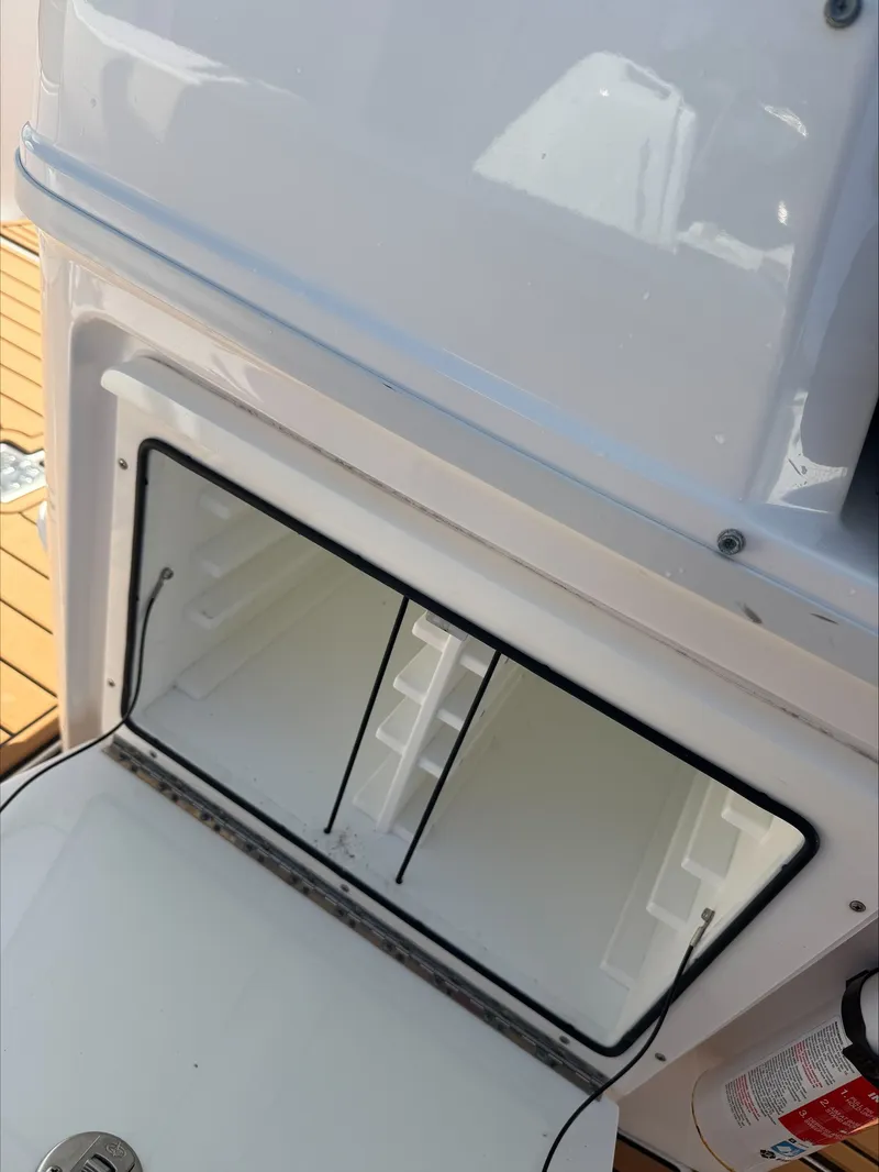 Slide: The Image of An open storage compartment on a boat with a white interior and wooden flooring. - 15