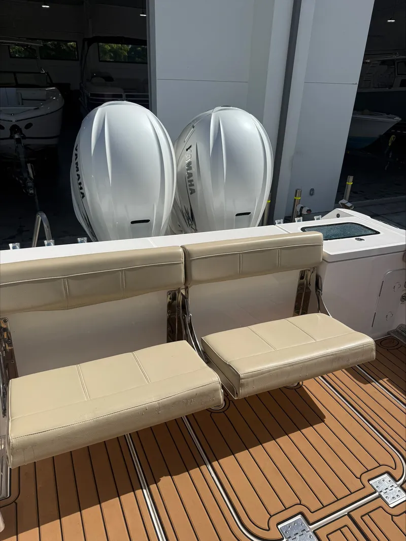 Slide: The Image of Two beige seats in front of two large outboard engines on a boat. - 8