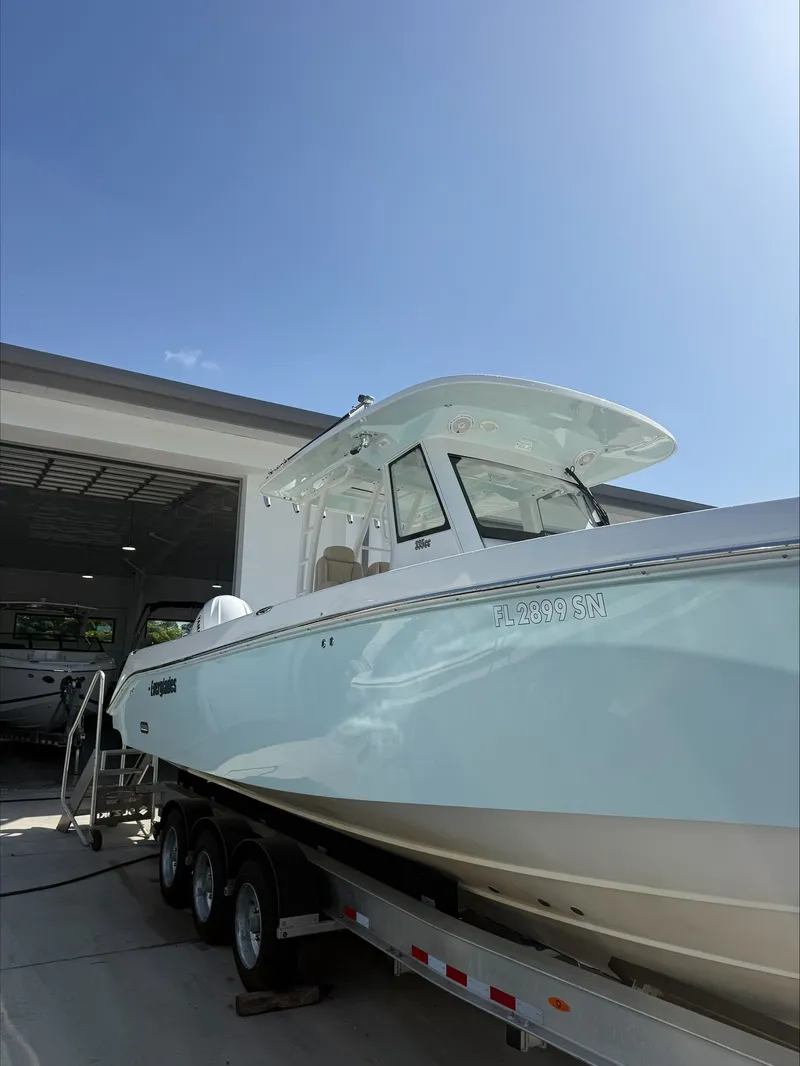 Slide: The Image of A 2020 Everglades 335 Center Console boat on a trailer outside a garage. - 3