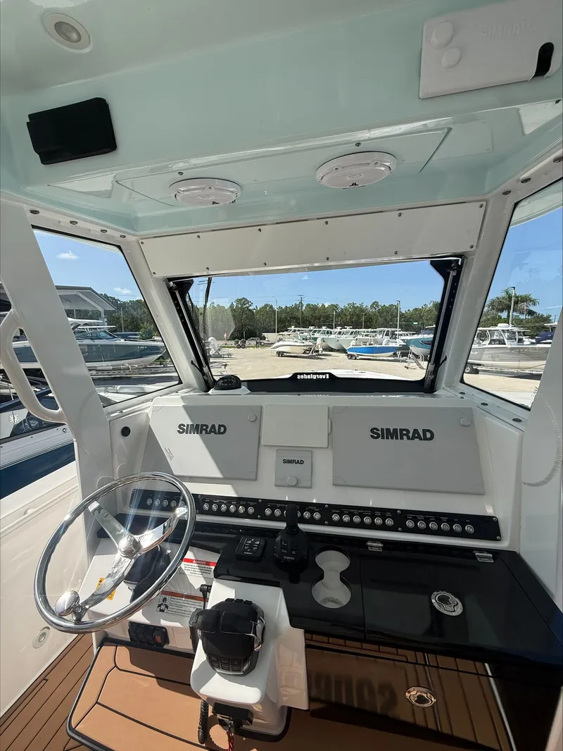 Slide: The Image of The cockpit of a 2020 Everglades 335 Center Console with Simrad electronics and a clear view outside. - 18
