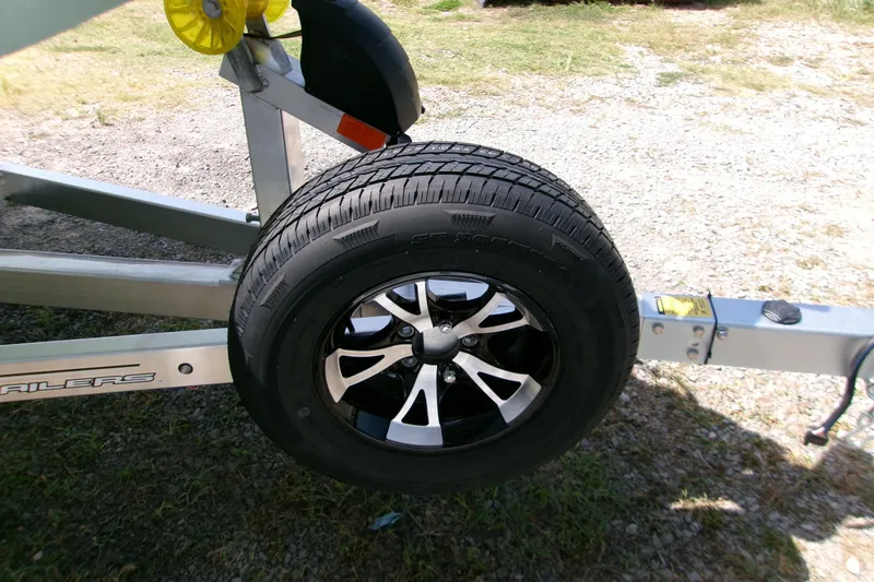 Slide: The Image of Trailer wheel of 2027 Xpress H22B Bay on gravel surface. - 18