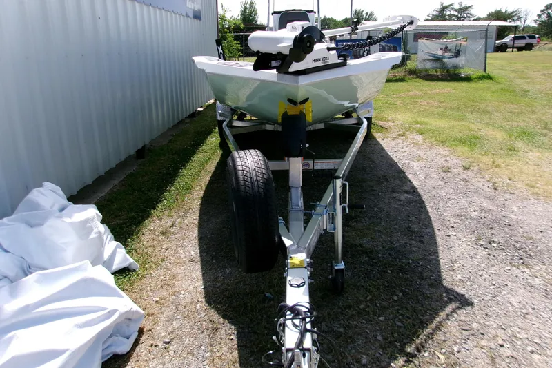 Slide: The Image of 2027 Xpress H22B Bay boat on trailer, parked outdoors near a metal building. - 17