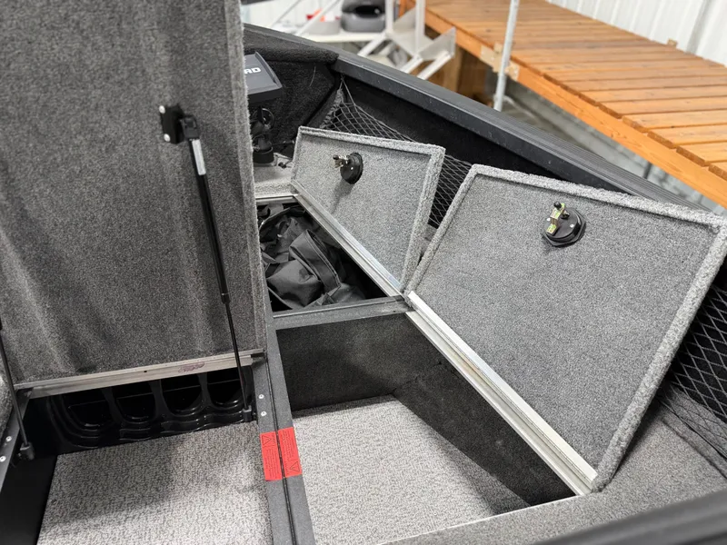 Slide: The Image of Interior view of an Alumacraft Competitor Shadow 175 Sport with storage compartments and gray carpeting. - 9