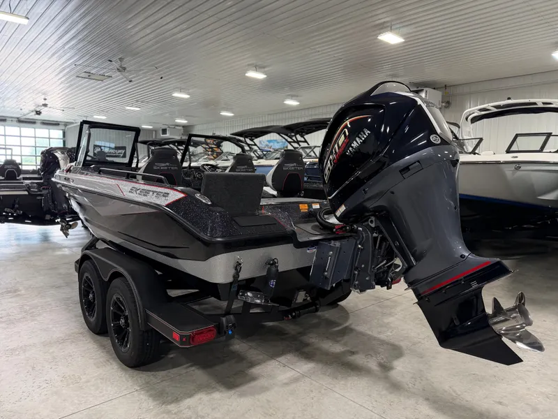 Slide: The Image of A 2026 Skeeter WXR1910F boat is in a showroom. It features a powerful outboard motor. - 8