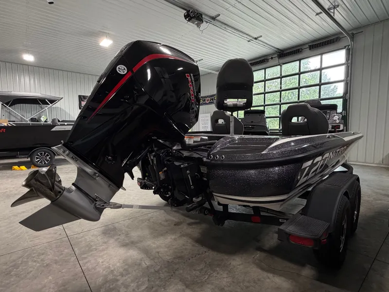 Slide: The Image of A 2024 Nitro Z20 Pro boat in a garage with a powerful outboard motor. - 5