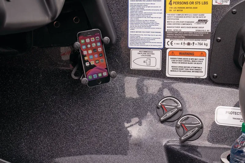 Slide: The Image of Close-up of a Nitro Z20 Pro boat dashboard with smartphone holder and warning labels. - 48