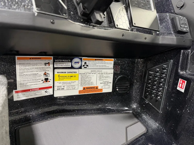 Slide: The Image of Close-up of a Skeeter WXR2060 boat dashboard with warning labels and control panels. - 22