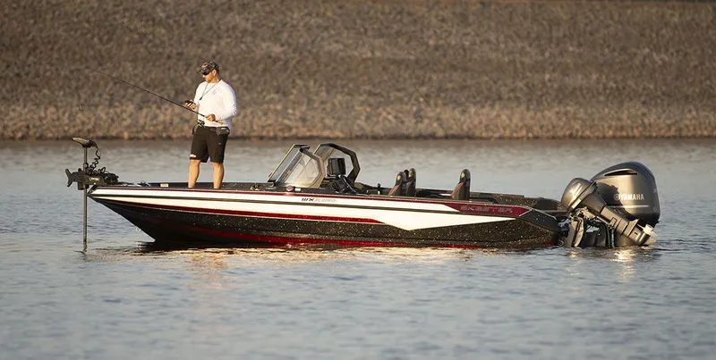 Slide: The Image of An angler stands on a 2026 Skeeter WXR2060 boat on calm water. - 50