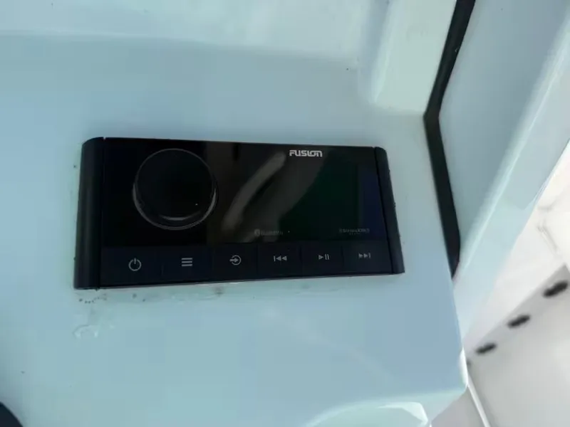 Slide: The Image of Close-up of a black Fusion marine audio system on a white boat. - 13