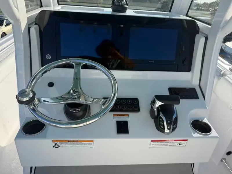Slide: The Image of The image shows the helm of a Sportsman Open 232 Center Console boat. - 10