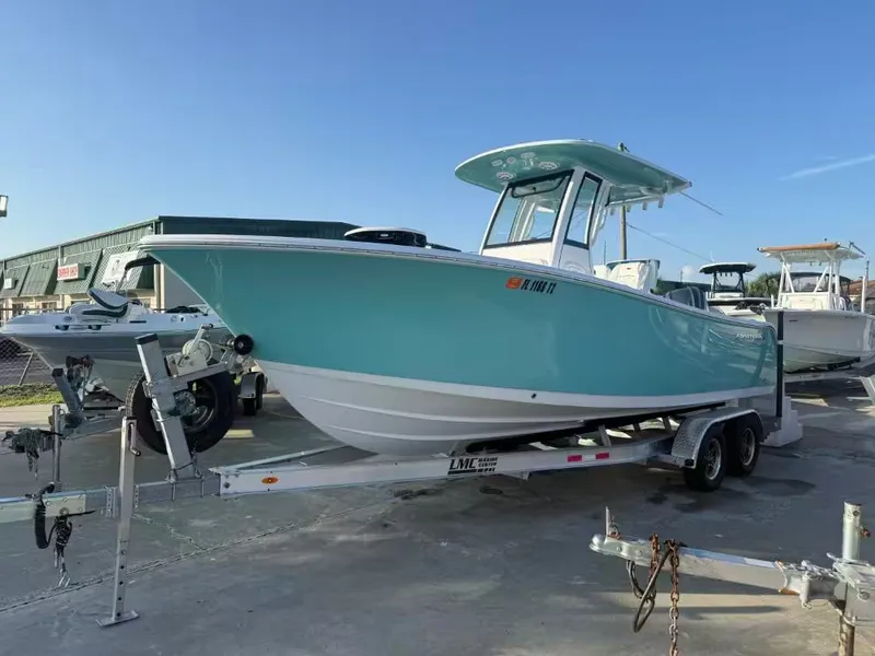 The Image of A turquoise sports boat on a trailer, ready for use on the water. - 1