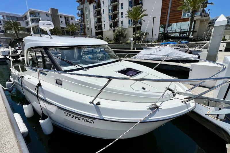 Slide: The Image of 2023 Beneteau Antares 8 docked at a marina, surrounded by modern buildings. - 18