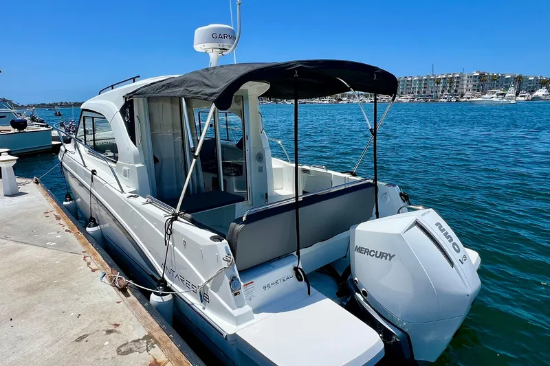 Slide: The Image of 2023 Beneteau Antares 8 boat docked, featuring Mercury engine, blue canopy, and marina backdrop. - 14