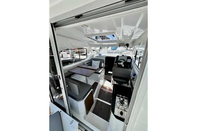 Slide: The Image of Interior view of 2023 Beneteau Antares 8 boat, featuring modern seating and navigation area. - 43