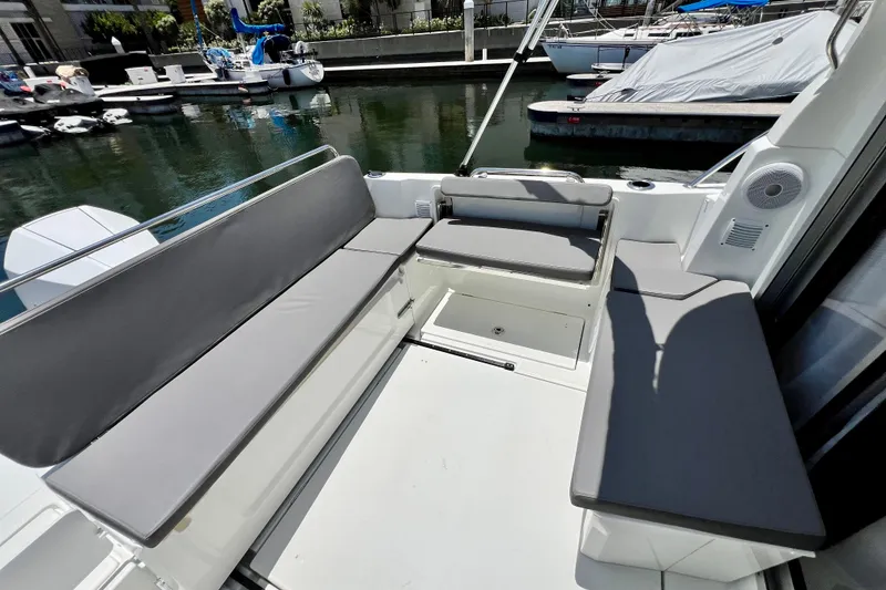 Slide: The Image of 2023 Beneteau Antares 8 boat interior with gray seating, docked at marina. - 29