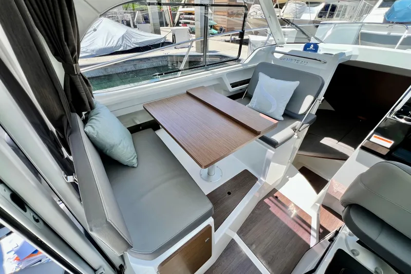 Slide: The Image of Interior of 2023 Beneteau Antares 8, featuring a cozy seating area with a wooden table. - 45