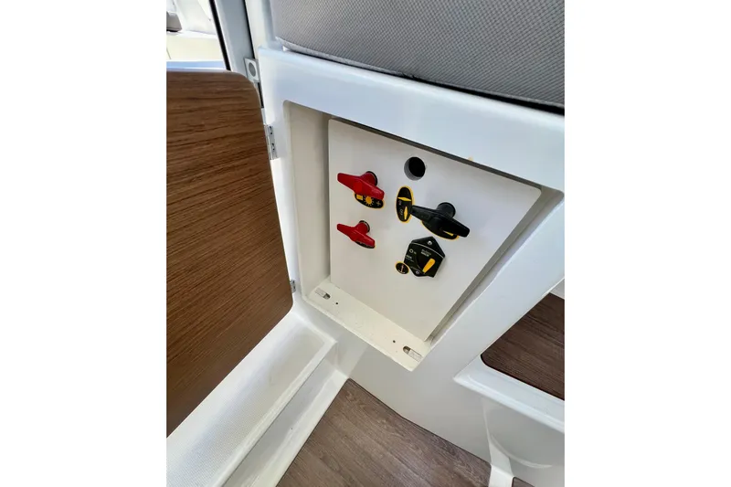 Slide: The Image of Control panel inside 2023 Beneteau Antares 8 boat, featuring switches and wooden accents. - 66