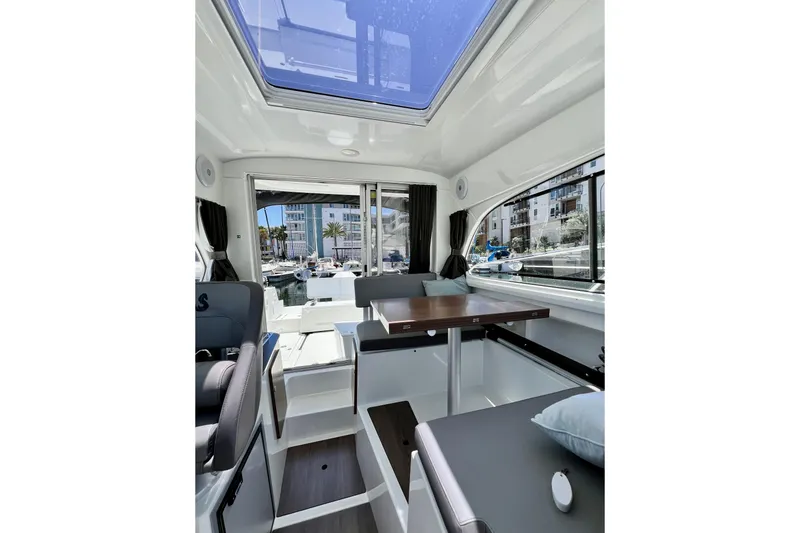 Slide: The Image of Interior of 2023 Beneteau Antares 8 boat, featuring modern seating and large windows. - 78