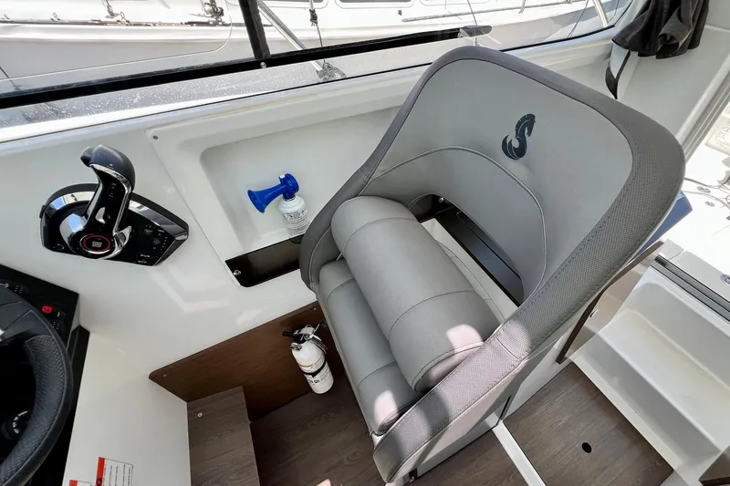 Slide: The Image of Captain's seat and controls in a 2023 Beneteau Antares 8 boat cockpit. - 60