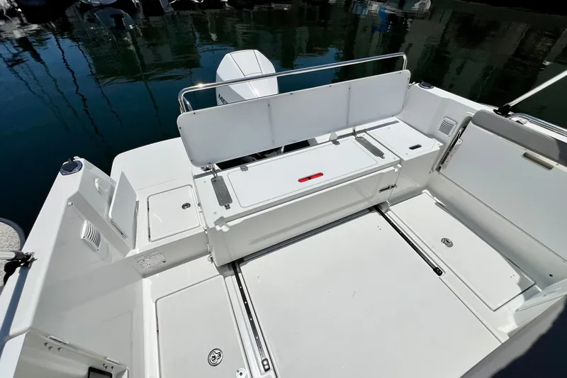 Slide: The Image of 2023 Beneteau Antares 8 boat deck with seating and storage, docked on calm water. - 37