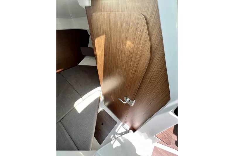 Slide: The Image of Interior cabin view of 2023 Beneteau Antares 8 with wooden door and seating area. - 75