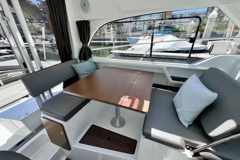 Slide: The Image of Interior of 2023 Beneteau Antares 8, featuring a cozy dining area with cushions. - 48