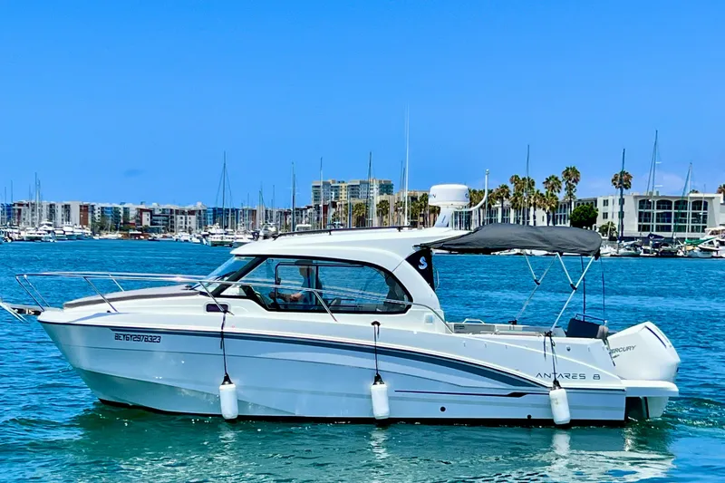 The Image of 2023 Beneteau Antares 8 boat cruising in a marina with clear blue skies. - 1
