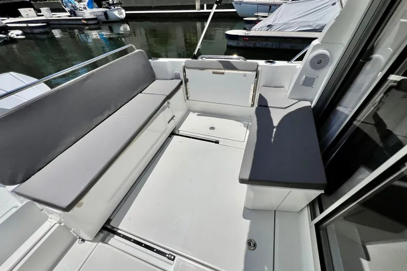 Slide: The Image of 2023 Beneteau Antares 8 boat seating area with gray cushions, docked at marina. - 30