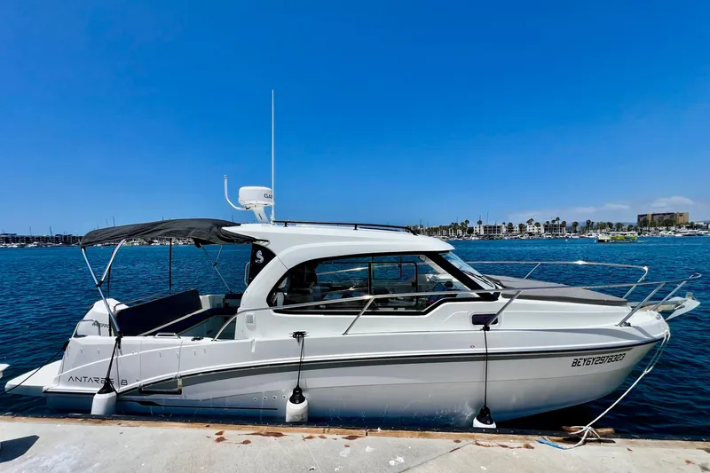 Slide: The Image of 2023 Beneteau Antares 8 boat docked at marina under clear blue sky. - 12
