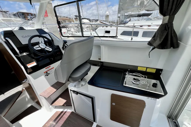 Slide: The Image of Interior of 2023 Beneteau Antares 8 boat with helm and compact kitchen area. - 62
