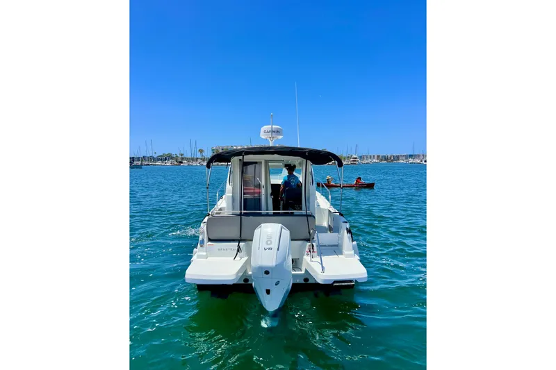Slide: The Image of 2023 Beneteau Antares 8 boat on water, rear view, sunny day, marina background. - 8
