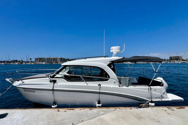 Slide: The Image of 2023 Beneteau Antares 8 boat docked by the marina under a clear blue sky. - 16