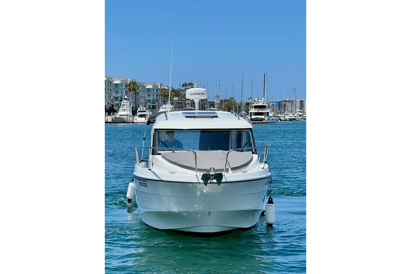 Slide: The Image of 2023 Beneteau Antares 8 boat cruising in a marina with clear blue skies. - 3