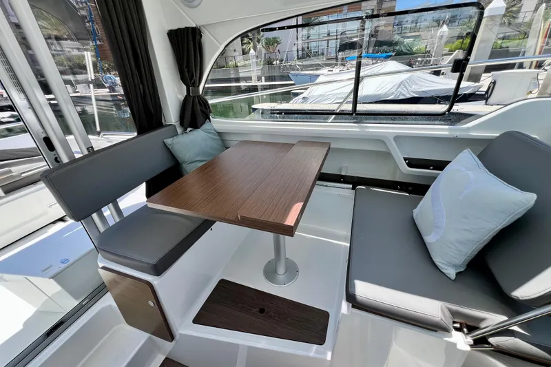 Slide: The Image of Interior of 2023 Beneteau Antares 8 with seating and wooden table, dock view. - 47
