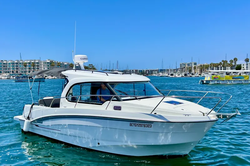 Slide: The Image of 2023 Beneteau Antares 8 boat cruising in a marina under clear blue skies. - 4