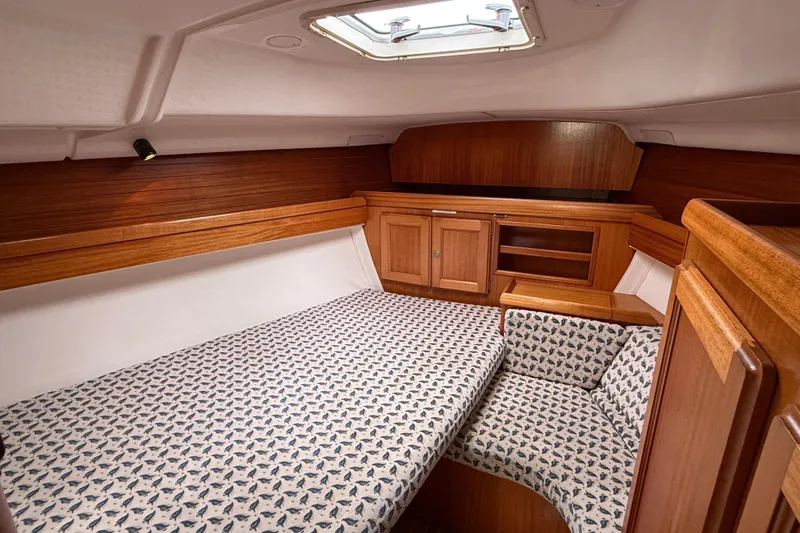 Slide: The Image of Cozy cabin interior of 2001 Dufour 36 Classic sailboat with wooden finish and patterned bedding. - 12