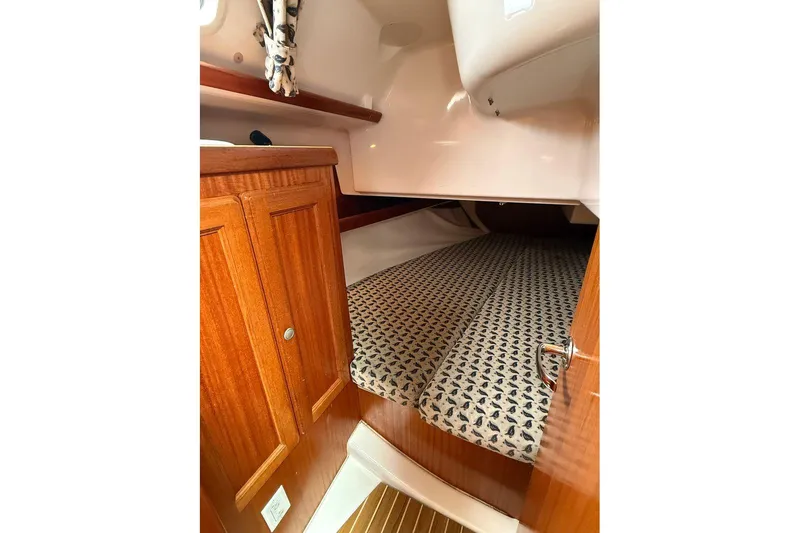 Slide: The Image of Interior cabin of 2001 Dufour 36 Classic sailboat with wooden cabinetry and patterned bedding. - 13