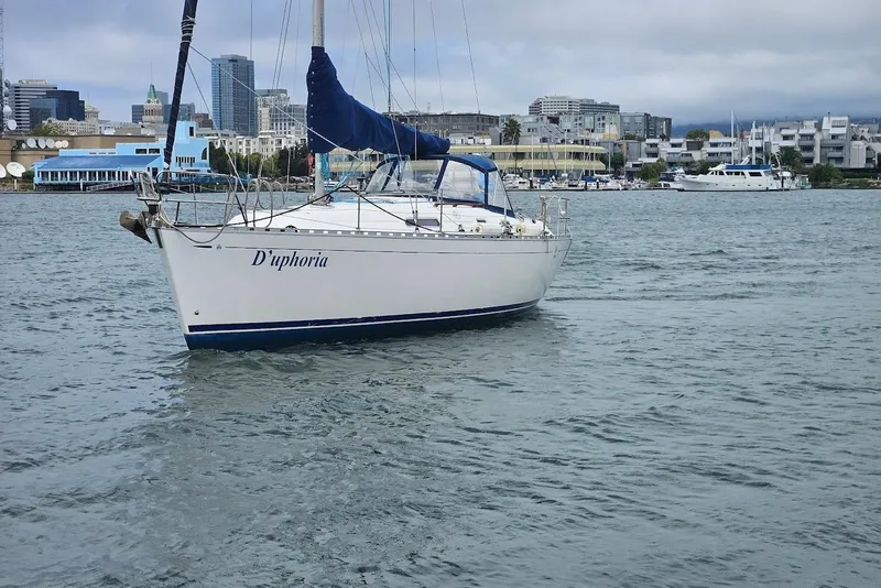 Slide: The Image of Sailboat "D'uphoria," Dufour 36 Classic 2001, on calm waters with cityscape background. - 2