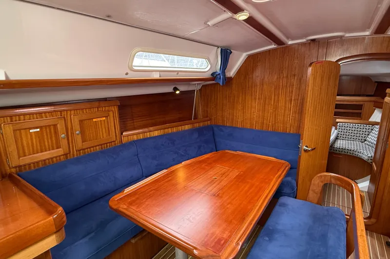Slide: The Image of Interior of 2001 Dufour 36 Classic yacht with wooden table and blue seating. - 11