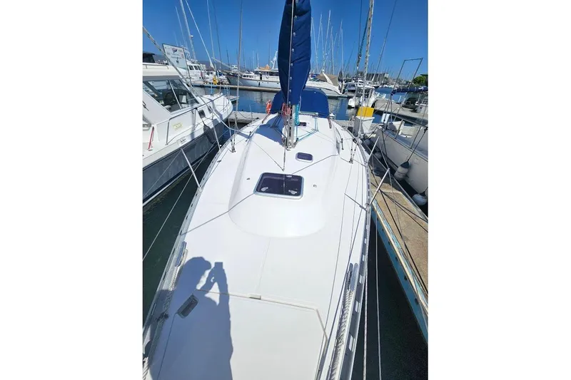 Slide: The Image of 2001 Dufour 36 Classic sailboat docked in a marina under clear blue skies. - 4