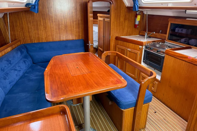 Slide: The Image of Interior of 2001 Dufour 36 Classic yacht with wooden dining area and blue seating. - 10
