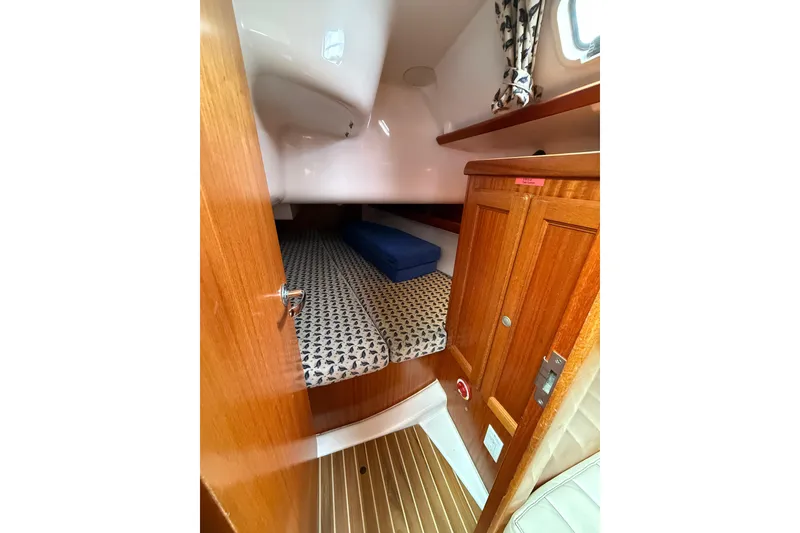 Slide: The Image of Cozy cabin interior of 2001 Dufour 36 Classic sailboat with wooden finish and patterned bedding. - 15