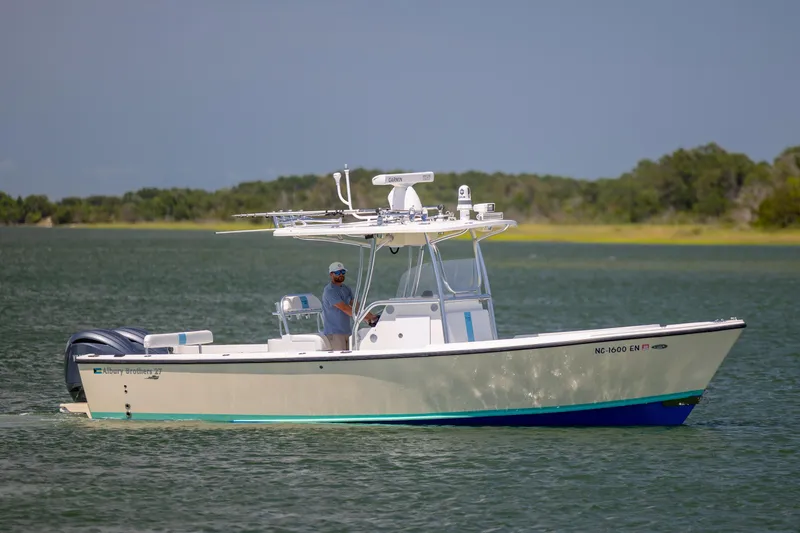 The Image of 2011 Albury Brothers 27 boat cruising on a calm lake with lush green shoreline. - 1