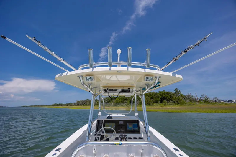 Slide: The Image of 2011 Albury Brothers 27 boat on water, clear sky, fishing rods extended. - 15