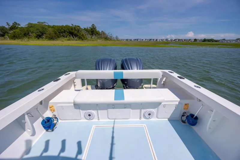 Slide: The Image of 2011 Albury Brothers 27 boat on water, featuring dual engines and spacious deck. - 19