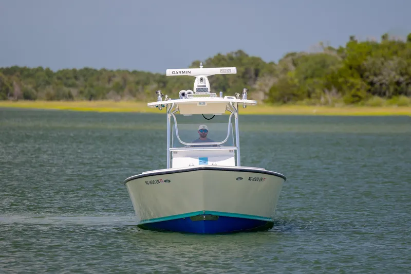 Slide: The Image of 2011 Albury Brothers 27 boat cruising on a calm lake with lush green shoreline. - 2