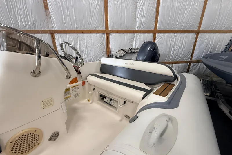 Slide: The Image of 2014 Walker Bay Generation 450 DLX boat interior with steering wheel and seating. - 5