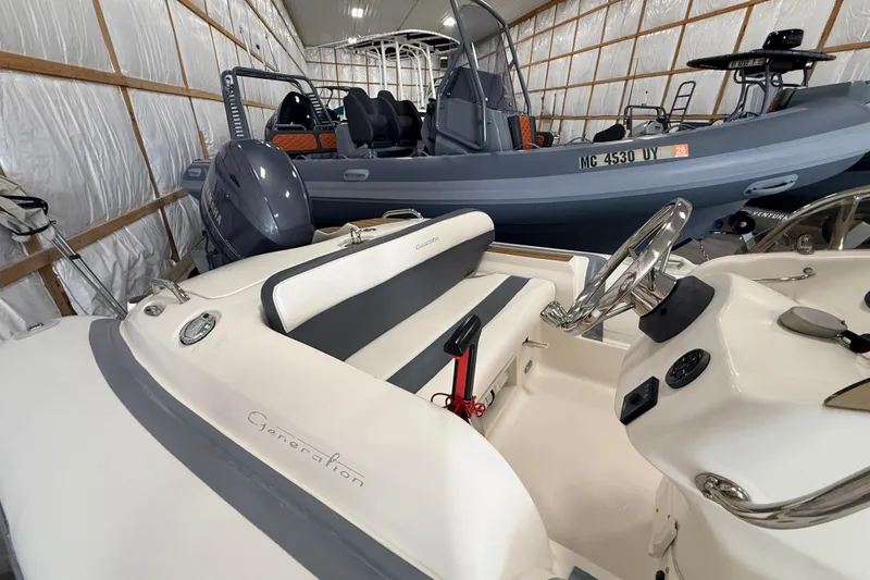 Slide: The Image of 2014 Walker Bay Generation 450 DLX boat interior in storage, featuring steering wheel and seating. - 14