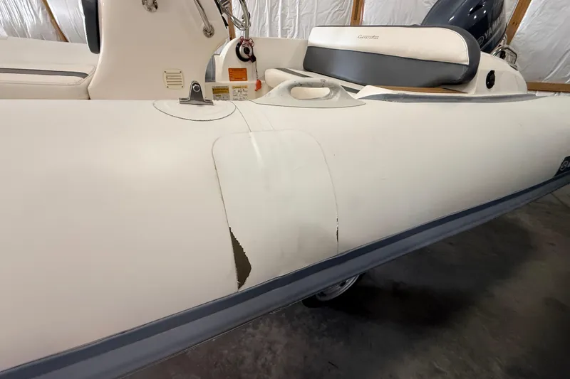 Slide: The Image of 2014 Walker Bay Generation 450 DLX boat with visible wear on the side. - 7