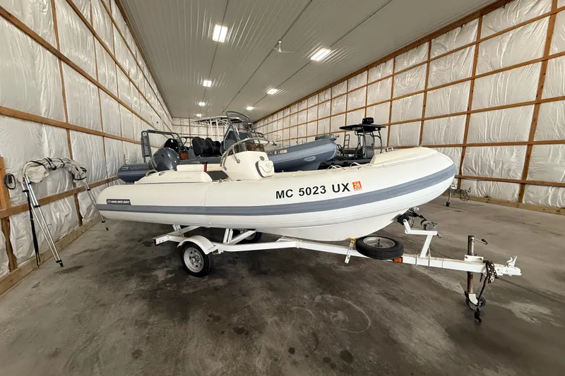 The Image of 2014 Walker Bay Generation 450 DLX boat on trailer in storage facility. - 1
